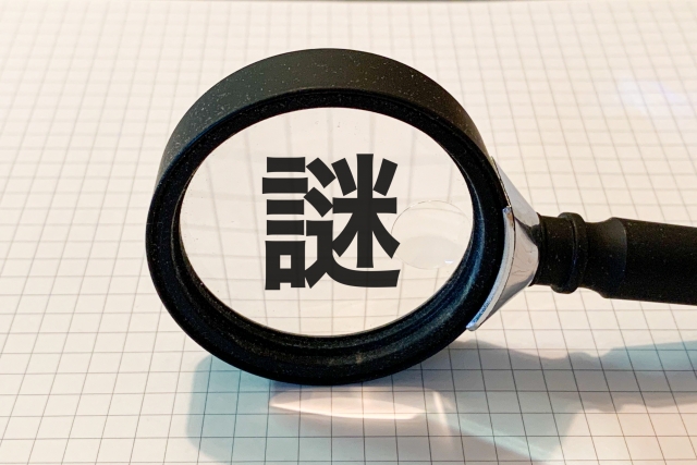 虫眼鏡で「謎」の文字を拡大するイメージ